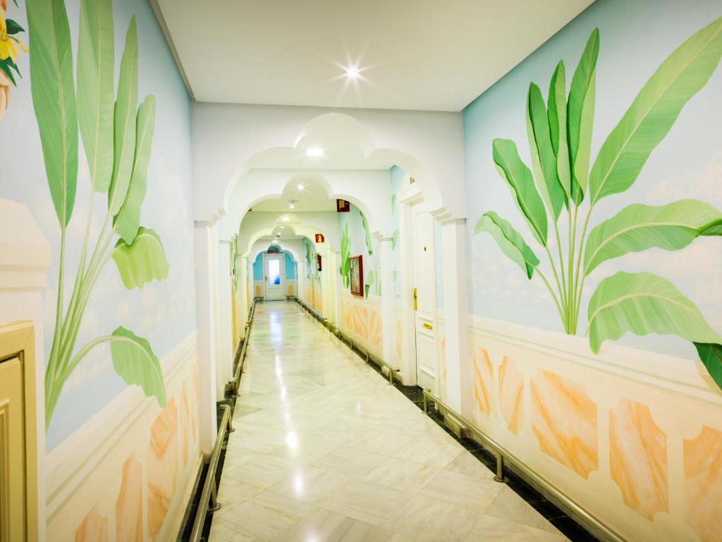 Gaišs un plašs koridors ar krāsainām sienu gleznām, kas attēlo zaļus augus. Grīda ir izklāta ar marmoru, un gaismas ir mīksti iedegtas, radot patīkamu atmosfēru.