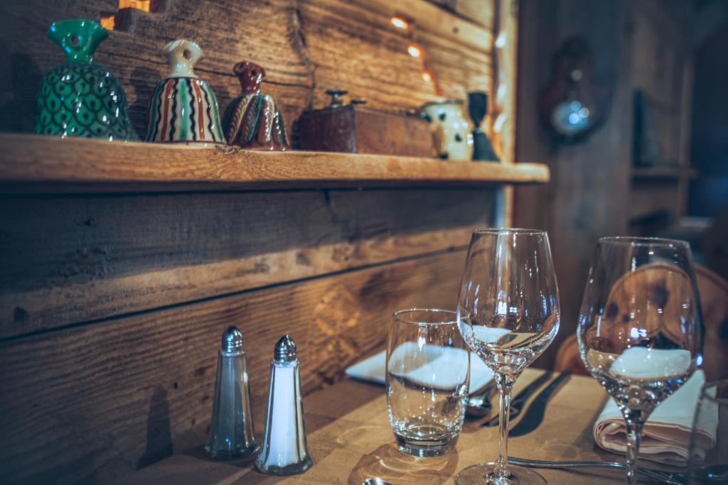 Gaišs un siltāks restorāna interjers ar koka sienām, uz kurām novietoti krāsaini dekori. Uz galda atrodas glāzes un sāls un piparu trauki, radot viesmīlīgu atmosfēru.