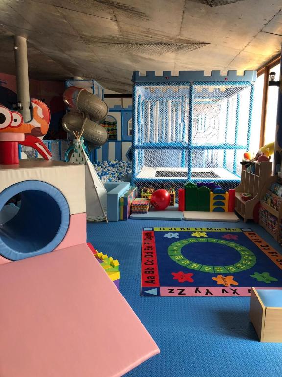 Bērnu rotaļu telpa ar krāsainiem mīkstajiem elementiem, slidkalniņu un spēļu laukumu. Iekārtota ar mīksto paklāju un dažādām rotaļlietām, veidojot drošu un jautru vidi bērniem.
