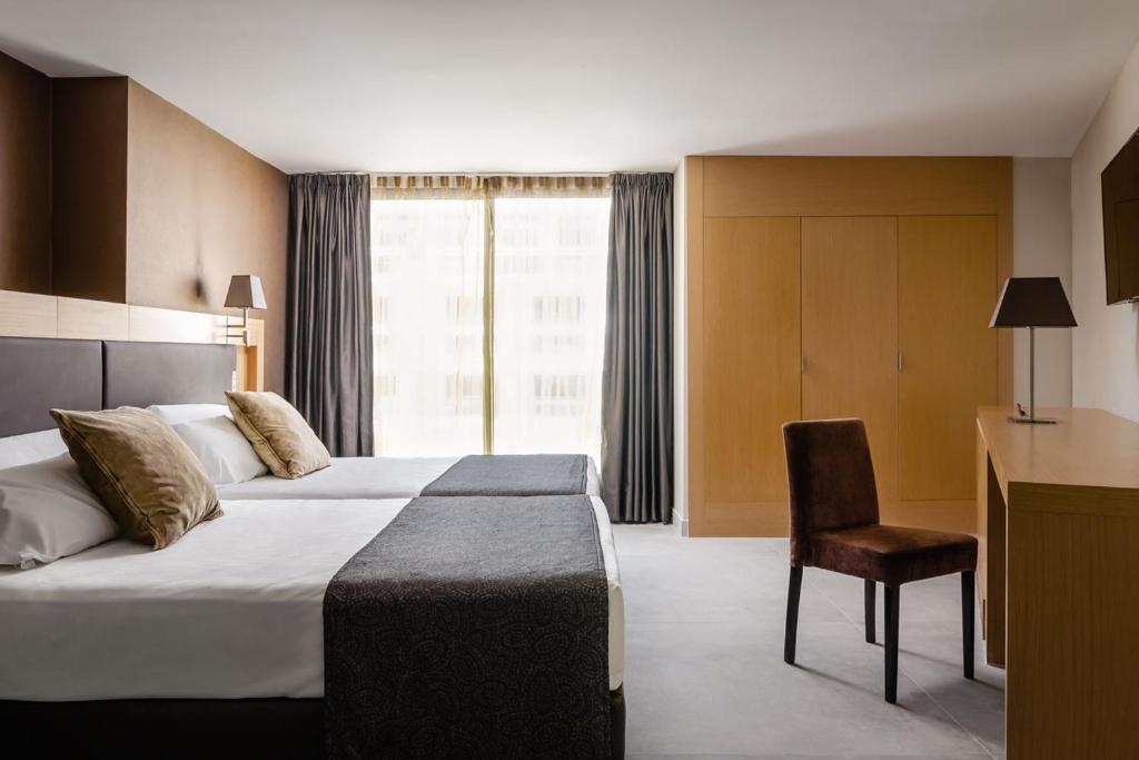 Mūsdienīga viesnīcas numura iekārtojums ar divām gultām, ērtām spilveniem un koka mēbelēm. Labi apgaismots numurs ar logiem, kas sniedz skatījumu uz ārpusi.