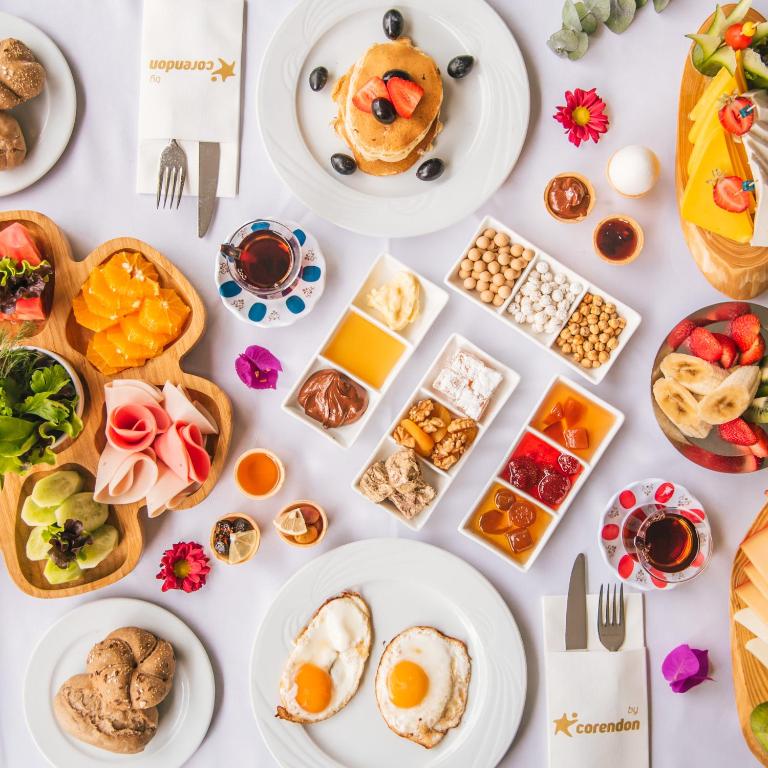 Bagātīgs brokastu galds ar pankūkām, olām, augļiem, salātiem un dažādiem piedevām. Izsmalcināta garša un krāsains ēdiens, kas aicina baudīt rītu.