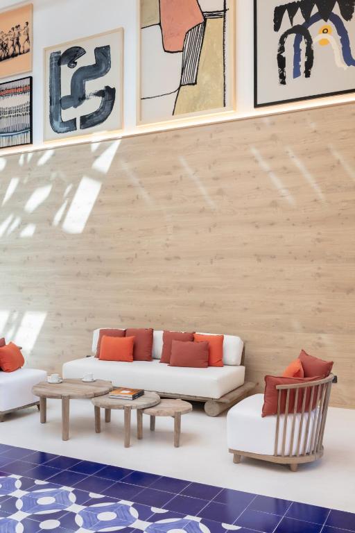 Mūsdienīgs viesistabas interjers ar gaišiem dīvāniem un spilveniem, kā arī mākslas darbiem uz sienas. Eleganta un ērta telpa ar koka akcentiem un zilu grīdu.