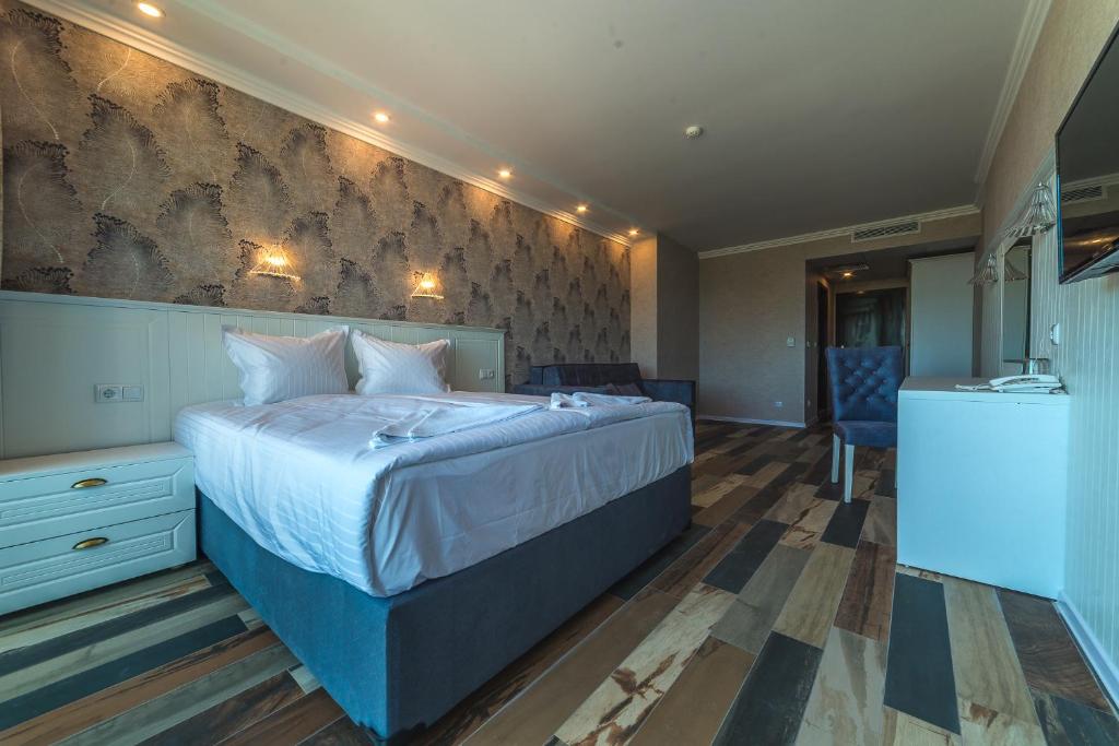 Mūsdienīgs viesnīcas numurs ar elegantu interjeru, divguļamo gultu un koka grīdu. Telpā ir ērta atpūtas zona un televizors.