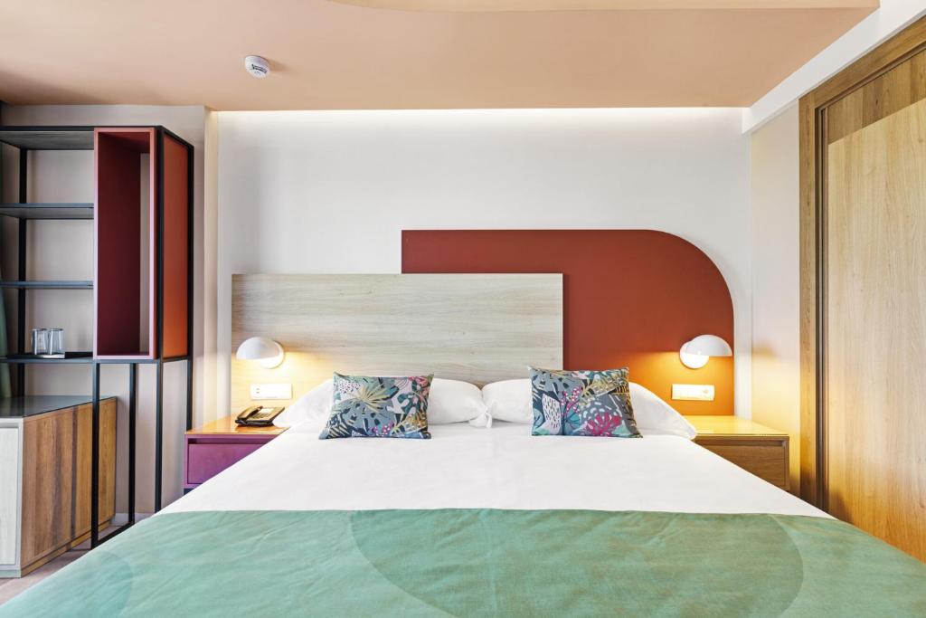 Mūsdienīga guļamistaba ar ērtu gultu, dekoratīvām spilveniem un stilīgu interjeru, kas ietver koka un metāla elementus. Gaismas un krāsu kombinācija rada relaksējošu atmosfēru.