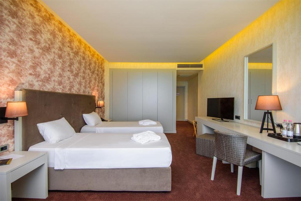 Moderns viesnīcas numurs ar divām atsevišķām gultām, rakstāmgaldu un televizoru. Interjeru raksturo siltas krāsas un eleganta apgaismojuma elementi.