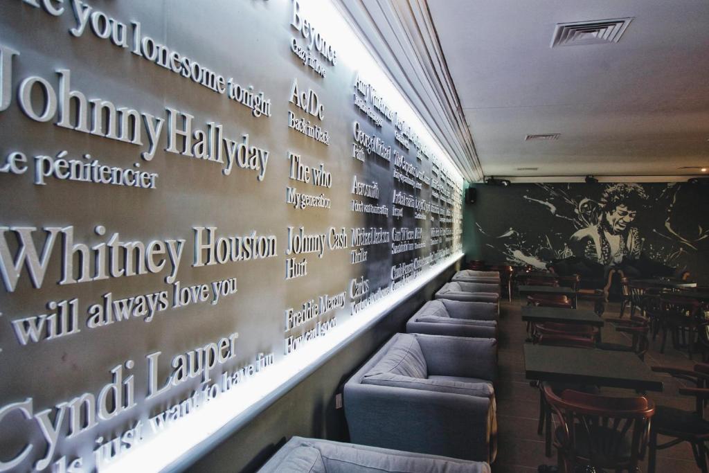 Kafejnīcas iekšējā siena ar izciliem mūziķu vārdiem un citātiem, radot radošu un muzikālu atmosfēru. Interjers ir moderns un aicinošs, ar ērtām mēbelēm un mākslas elementiem.