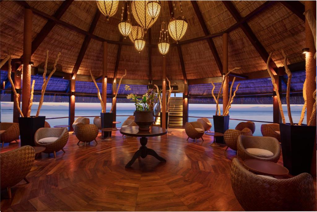 Elegants interjers ar koka grīdu un tradicionālu jumtu, apgaismots ar stilīgām lampām, piedāvā relaksējošu atmosfēru ar skatu uz jūru. Sēdvietas ir veidotas no dabīgiem materiāliem, radot mājīgu un komfortablu vidi.