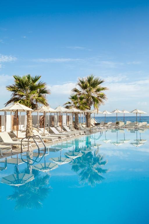 Vasaras brīvdienu oāze ar palmām un baseinu, kas atspoguļo skaidro debesu un pludmales atmosfēru. Ideāla vieta atpūtai un relaksācijai.