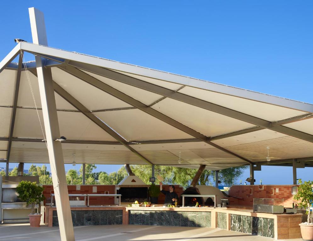 Modernā āra virtuve ar nojumi, akmens darba virsmām un grilu, ideāli piemērota ēdienu gatavošanai un svinībām. Kluss un saulains laiks ar skatu uz dabu.