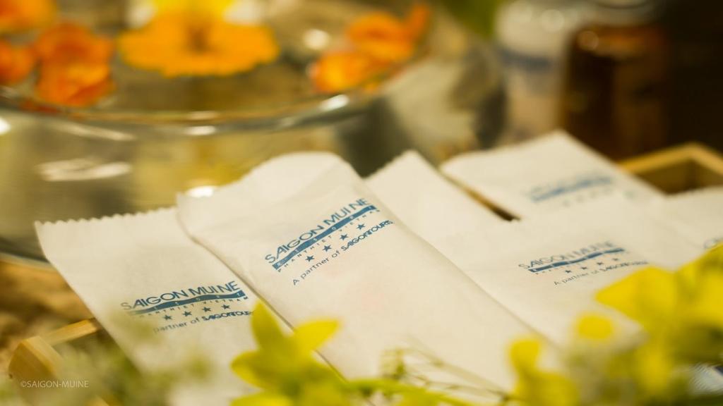 Saigon Muine zīmola salvetes ir novietotas blakus ziediem un citiem dekoratīviem elementiem, radot viesmīlīgu atmosfēru.