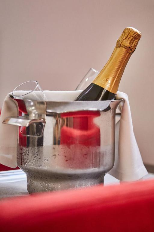 Šampanieša pudele atrodas ledus spainī, blakus divi glāzes, radot svinīgu atmosfēru.