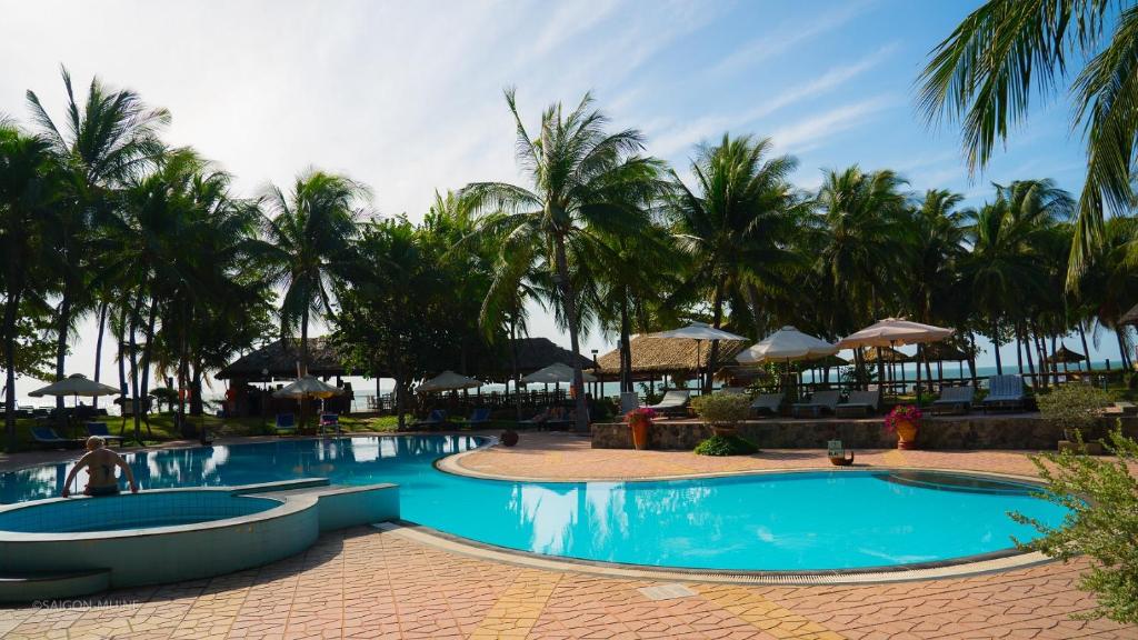 Vasaras atpūtas vieta ar peldbaseinu, palmām un saulessargiem, kas piedāvā relaksējošu atmosfēru pie pludmales. Ideāla vieta atpūtai un izklaidei.