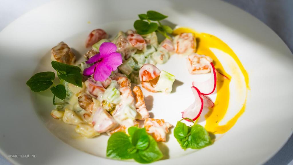 Svaigu dārzeņu un garneles salāti ar ziedu dekoru un krāsainu mērci. Ideāls veselīgs ēdiens.