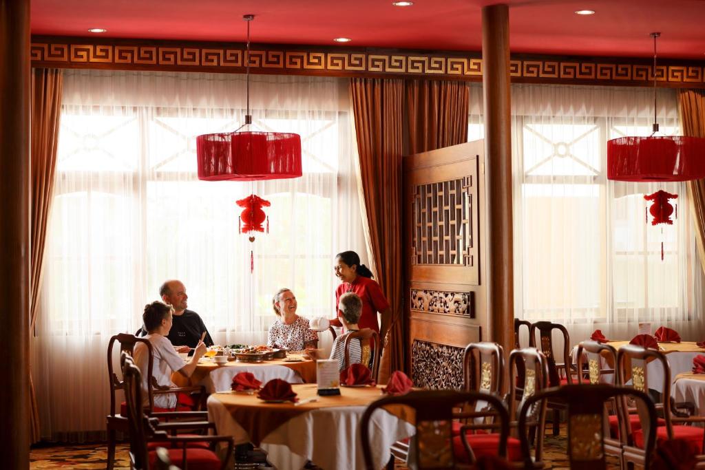 Restorāns ar siltu atmosfēru, kur ģimene bauda maltīti, kamēr viesmīle apkalpo. Interjers ir dekorēts ar ķīniešu elementiem un siltām krāsām.