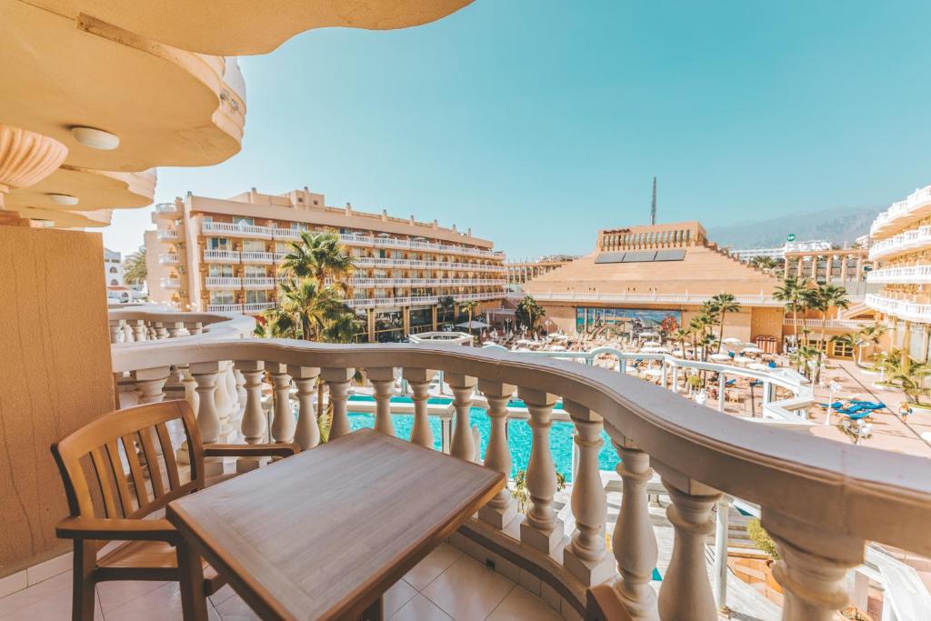 Balkons ar skatu uz viesnīcu un baseinu, apkārt palmām un saulainam laikam. Ideāla vieta atpūtai un relaksācijai.