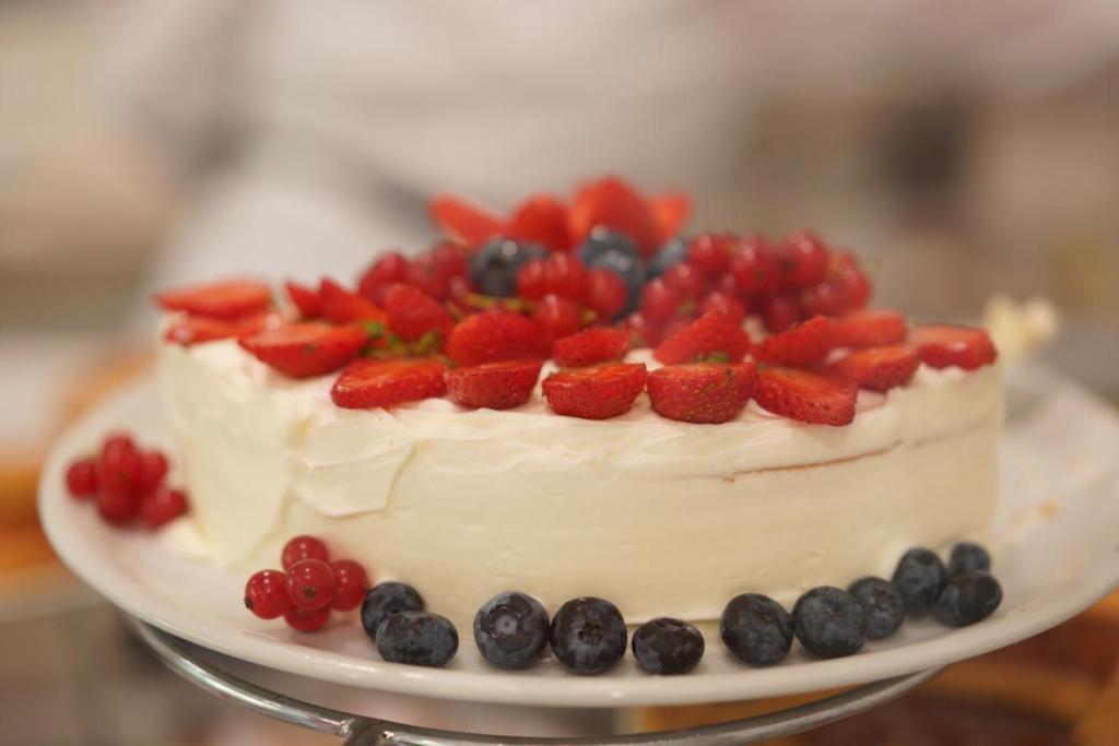 Svaiga un krāsaina kūka, pārklāta ar krēmīgu glazūru un rotāta ar zemenēm, mellenēm un avenēm. Ideāla izvēle svinībām un desertiem.