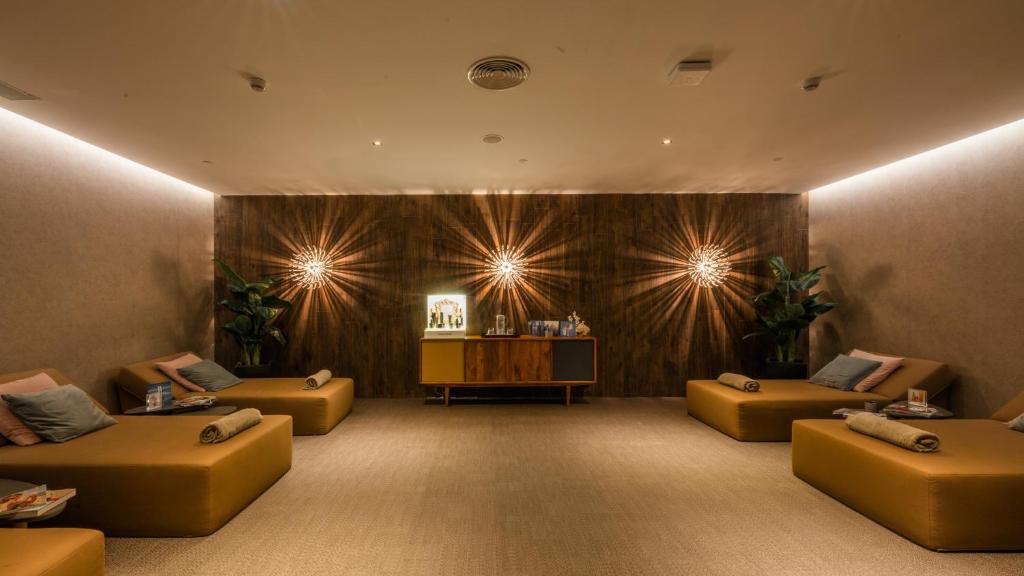 Relaksējoša spa telpa ar komfortablām atpūtas zonām, siltu apgaismojumu un augiem, radot mierīgu atmosfēru. Ideāla vieta relaksācijai un atpūtai.