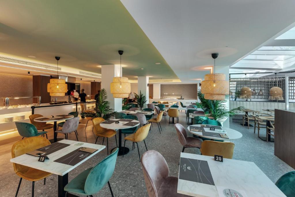 Mūsdienīgs restorāns ar stilīgiem galdiem un krēsliem, apgaismots ar elegantiem lampām. Telpā ir daudz zaļumu un gaišs interjers, kas rada patīkamu atmosfēru.