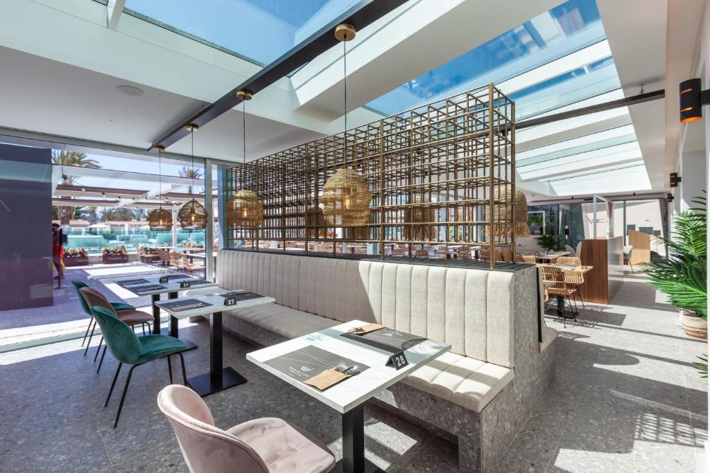 Moderns restorāns ar gaišu interjeru, kas piedāvā komfortablu sēdvietu, lieliem logiem un rotājumiem no vītinātas zāles. Telpā ir redzams baseins un āra terase.