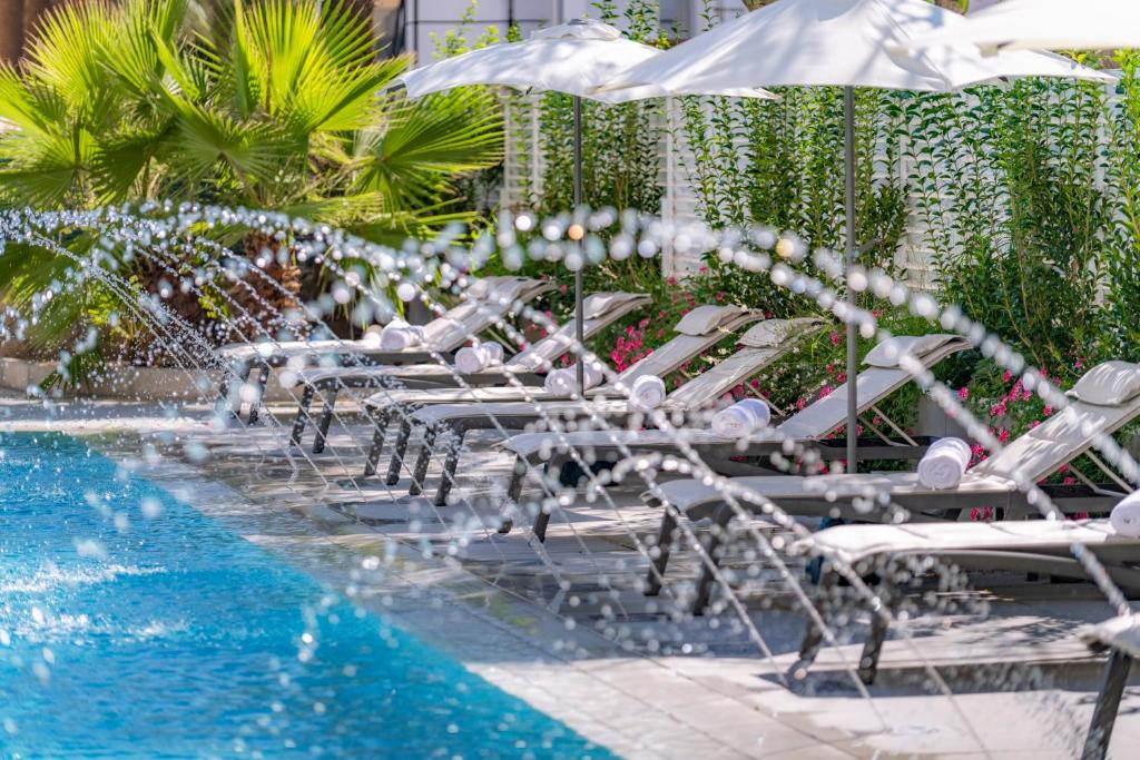 Baseins ar saulessargiem, blakus ziedošām augu kompozīcijām un ūdens strūklakām, radot relaksējošu un mierīgu atmosfēru.