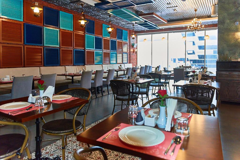 Rose Park Hotel Al Barsha restorāns ar stilīgu interjeru.