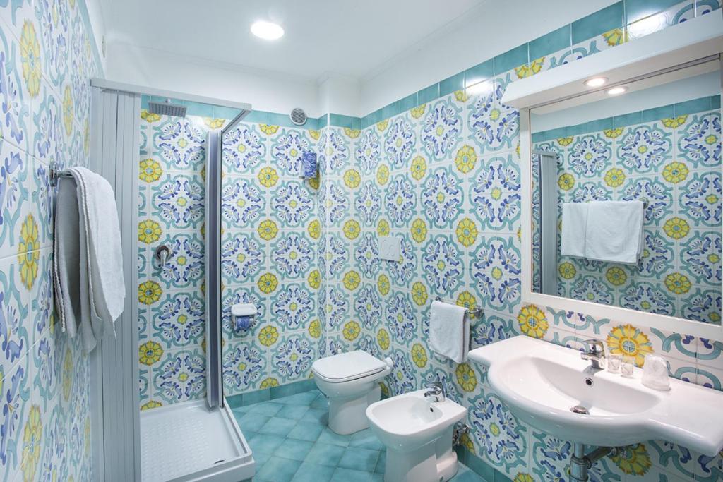 Vannas istaba ar krāsainām flīzēm, dušas kabīni un mūsdienīgu sanitāro tehniku. Gaisma rada patīkamu atmosfēru.