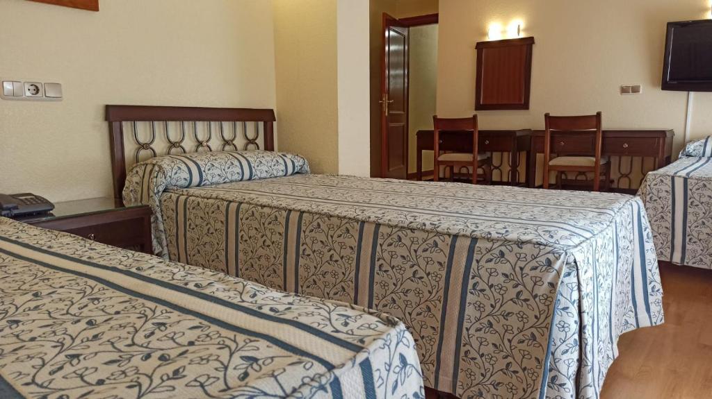 Istaba ar trīs gultām, apklātām ar ziedu raksta gultasveļu, un koka mēbelēm. Sienās ir televizors un mazs rakstāmgalds ar krēsliem.