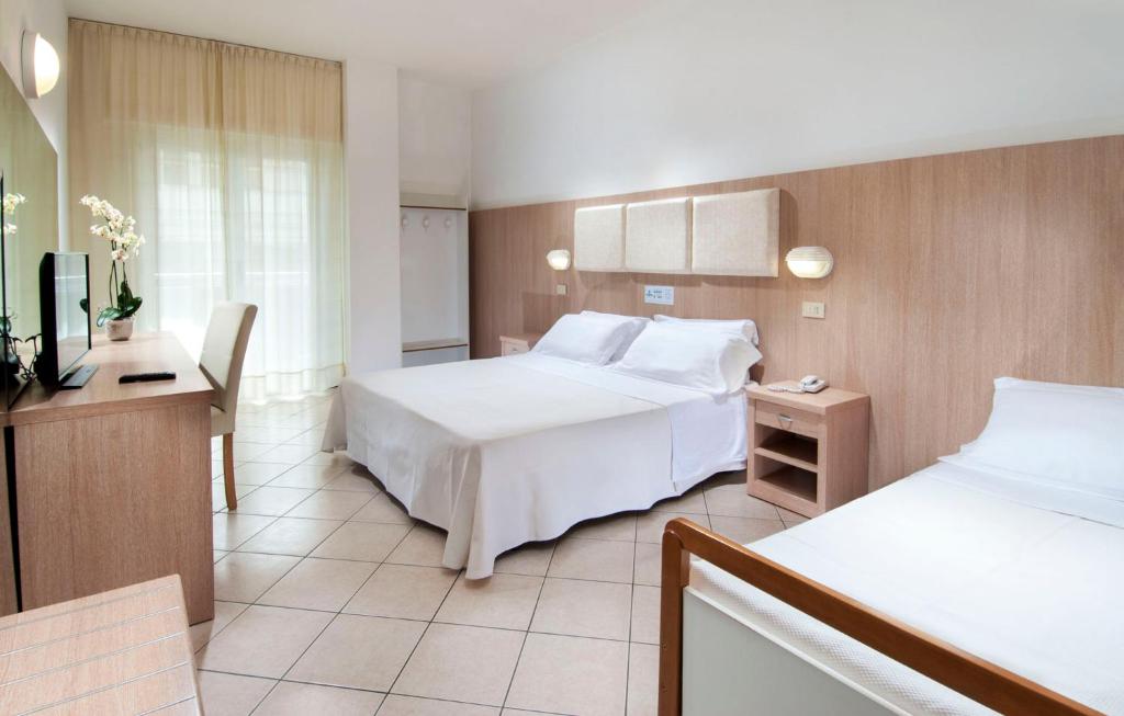 Mūsdienīgs viesnīcas numurs ar divām gultām, televizoru un koka mēbelēm, kas nodrošina komfortu un ērtību. Lielas logu aizkari nodrošina dabiski apgaismojumu.