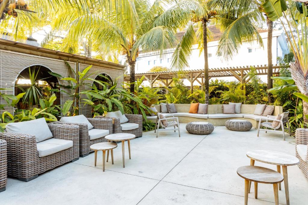 Āra atpūtas zona ar ērtām vītņu mēbelēm, zālēm un palmām, kas rada relaksējošu atmosfēru. Ideāli piemērota socializēšanās brīžiem vai relaksācijai dabā.