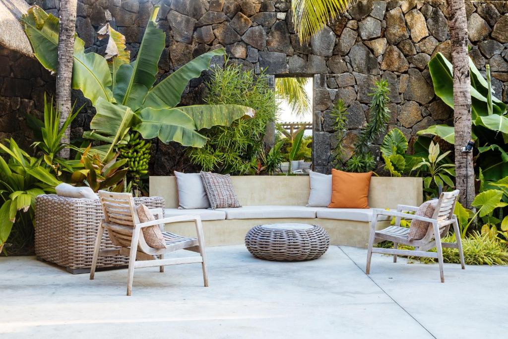 Dabīgā stilā iekārtota terase ar ērtu sēdvietu un eksotiskām augiem fonā. Terase ir veidota no dabīgiem materiāliem un izstaro mierīgu atmosfēru.