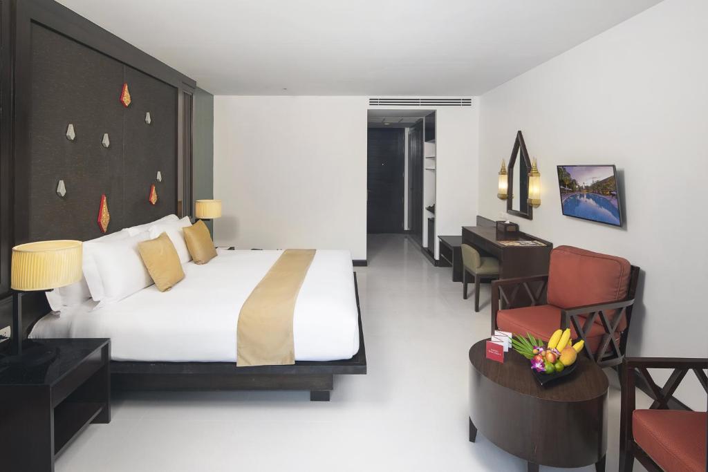 Mūsdienīgs viesnīcas numurs ar plašu gultu, modernām mēbelēm un dekoratīvām detaļām. Telpā ir arī dīvāns, galda un televizora zona, kas nodrošina komfortablu atpūtu.