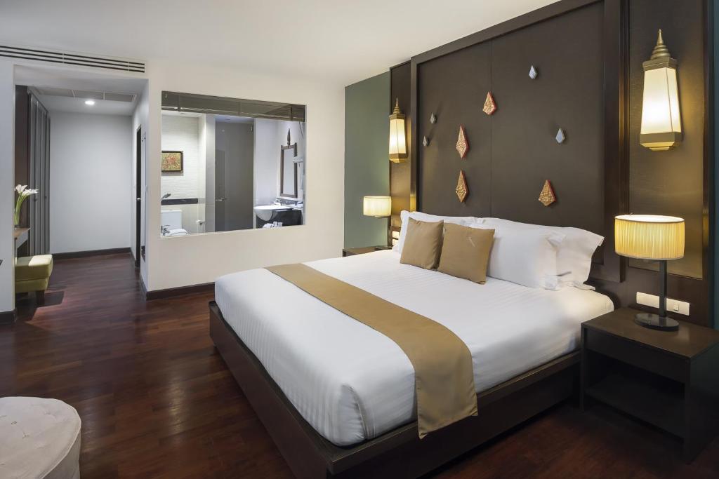 Mūsdienīgs viesnīcas numurs ar plašu gultu, elegantu apgaismojumu un koka grīdu, radot siltu un viesmīlīgu atmosfēru. Numurā ir arī liels spogulis un moderns vannas istabas dizains.