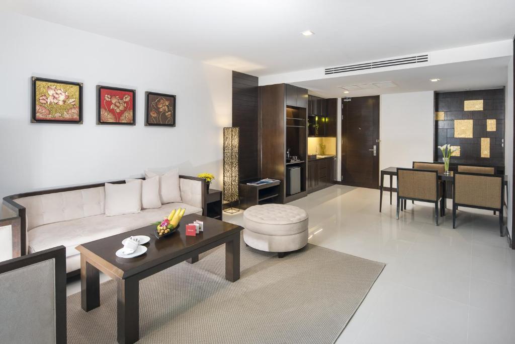 Mūsdienīgs viesnīcas numurs ar elegantu viesistabu, kas ietver dīvānu un kafijas galdiņu, kā arī izsmalcinātu virtuvi un ēdamzonu. Sienas rotā mākslas darbi, radot siltu un viesmīlīgu atmosfēru.