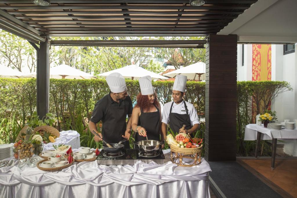 Šefpavāri gatavo maltīti ārā, izmantojot svaigus dārzeņus un augļus, kamēr ir skaista vasaras vide.