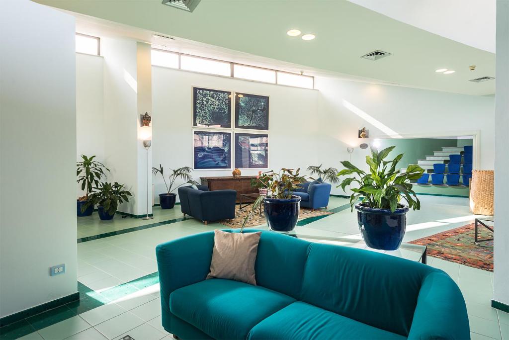 Rada Siri Hotel modernā atpūtas zona ar zaļu dīvānu un augiem.