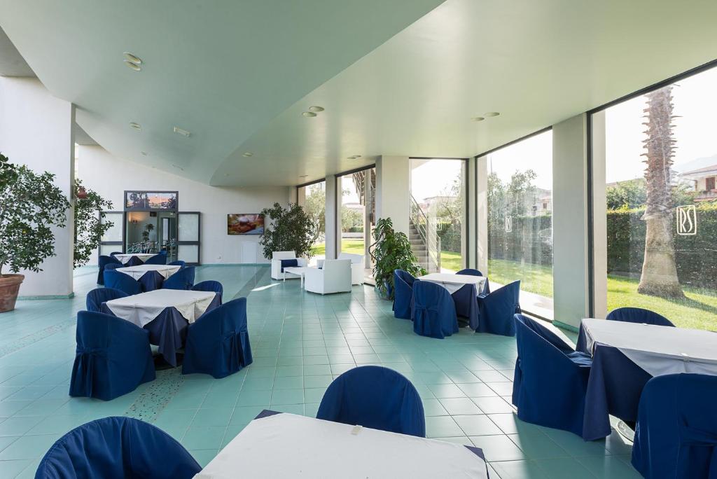 Rada Siri Hotel gaiša un plaša ēdamzāle ar skatu uz dārzu.