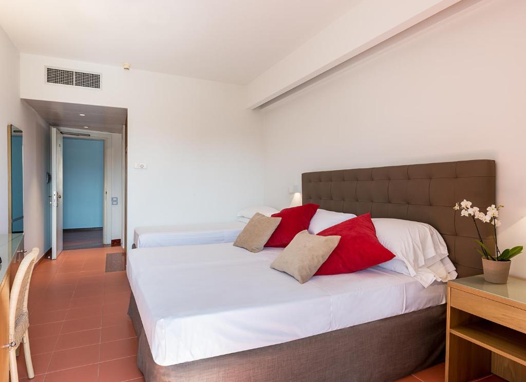 Rada Siri Hotel numurs ar ērtu gultu un spilgtiem spilveniem.