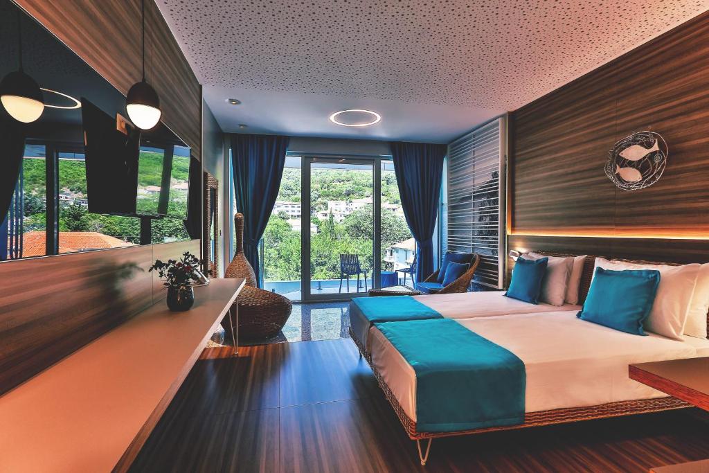 Mūsdienīgs viesnīcas numurs ar divām gultām, elegantām mēbelēm un skatu uz dabu. Telpa ir gaiša, ar lieliem logiem un stilīgu apgaismojumu.