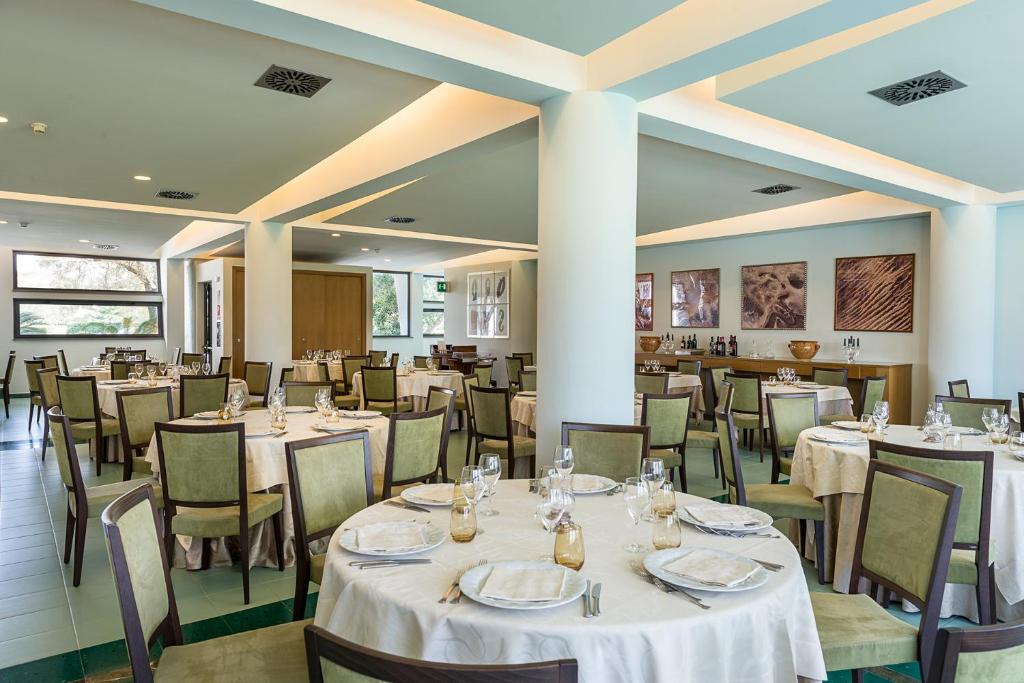 Rada Siri Hotel restorāns ar elegantām galda klājumiem.