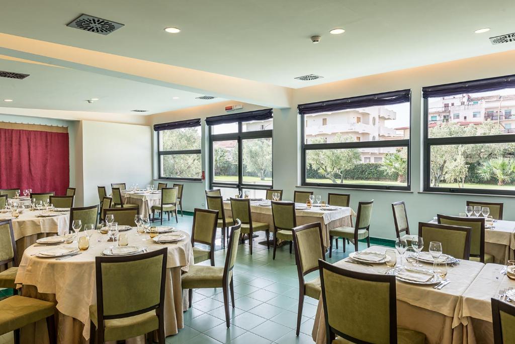 Eleganta Rada Siri Hotel restorāna zāle ar skatu uz zaļo ainavu.