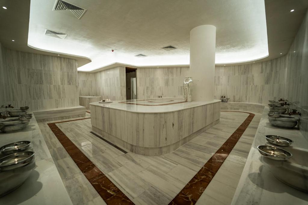 Mūsdienīgs spa interjers ar marmora sienām un grīdu, kas radīts relaksācijai un atpūtai. Telpā ir stilīgs apgaismojums un metāla trauki, kas piešķir eleganci.