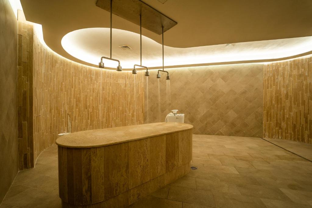 Mūsdienīgs un elegantas dizaina vannas istaba ar dabīgām akmens apdarēm un stilīgu apgaismojumu, radot relaksējošu atmosfēru.