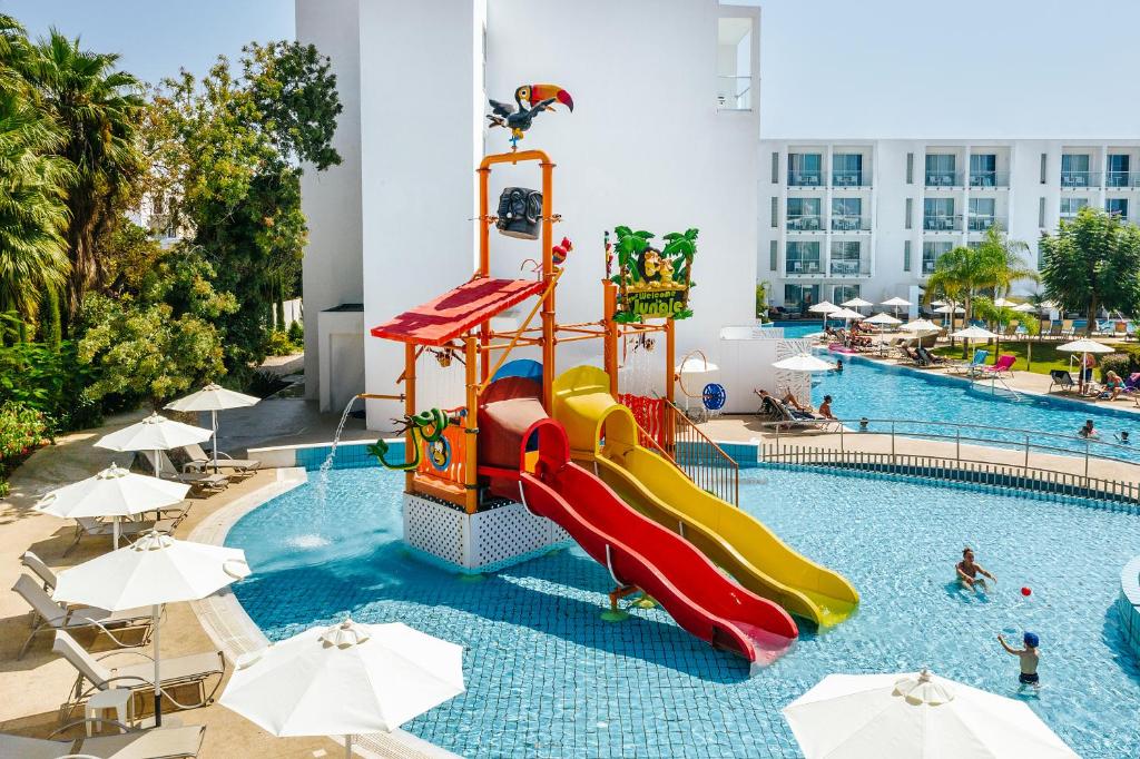 Ūdens atrakciju parks ar krāsainām slidkalniņām un bērniem baseinā, apkārt palmām un sauļošanās krēsliem. Ideāla vieta ģimenēm atpūtai.