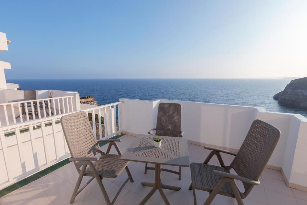 Jauka terase ar skatu uz jūru, kurā ir četri krēsli un galds. Ideāla vieta relaksācijai un atpūtai pie ūdens.