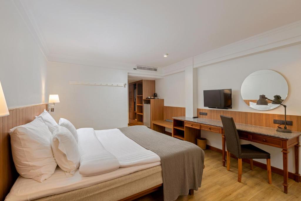 Mūsdienīgs viesnīcas numurs ar ērtu gultu, rakstāmgaldu un televizoru, nodrošinot komfortablu atpūtu. Gaismas toņi un koka akcenti radīs siltu atmosfēru.