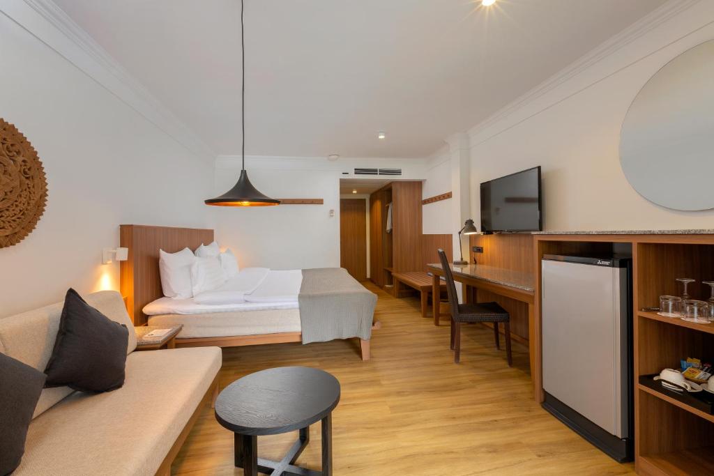 Mūsdienīgs viesnīcas numurs ar ērtu gultu, dīvānu un darba galdu, kurā ir televizors un mini ledusskapis. Interjers ir gaišs un viesmīlīgs ar koka grīdu un modernu apgaismojumu.