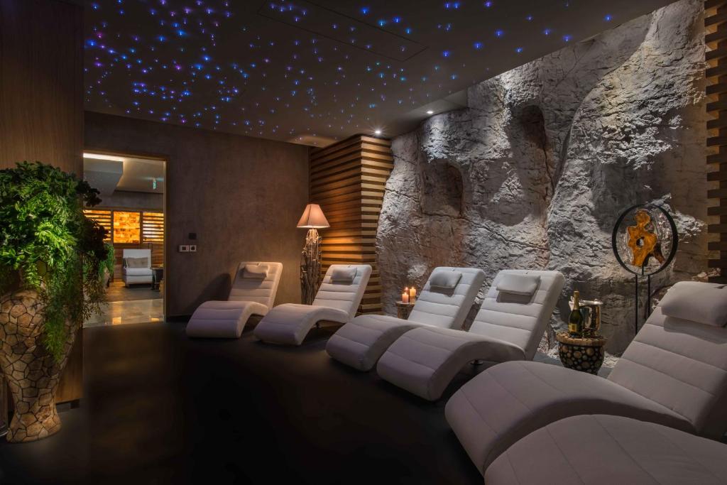 Mūsdienīga spa telpa ar relaksējošām guļamvietām un zvaigžņotu griestu apgaismojumu, radot mierīgu atmosfēru. Dabas elementi un moderns dizains veicina relaksāciju un atpūtu.