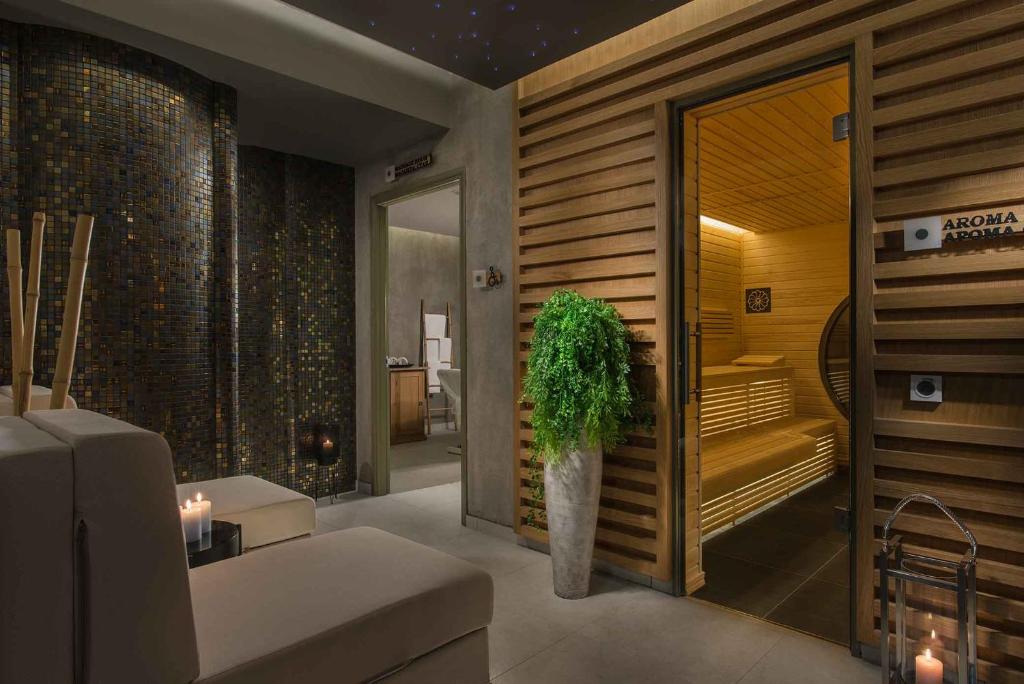 Mūsdienīga spa telpa ar relaksējošu atmosfēru, kurā redzama sauna un komfortablas atpūtas zonas. Interjeru papildina augu dekorācijas un siltas gaismas akcenti.