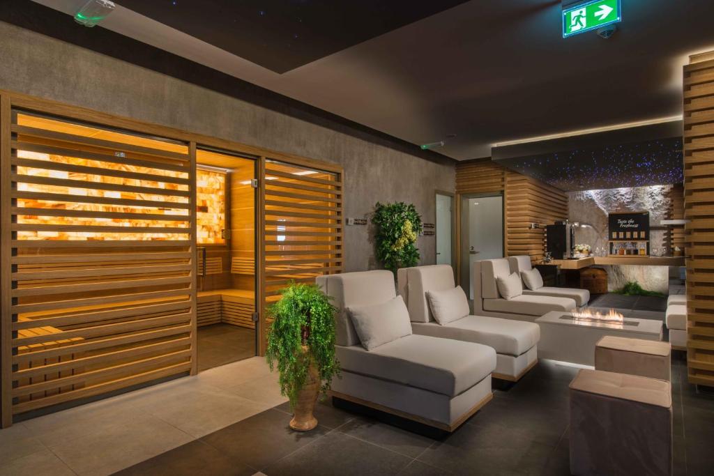 Mūsdienīgs spa interjers ar koka detaļām, relaksējošām atpūtas zonām un sāls saunu. Telpā ir arī augi un eleganta apgaismojuma elementi, radot mierīgu atmosfēru.