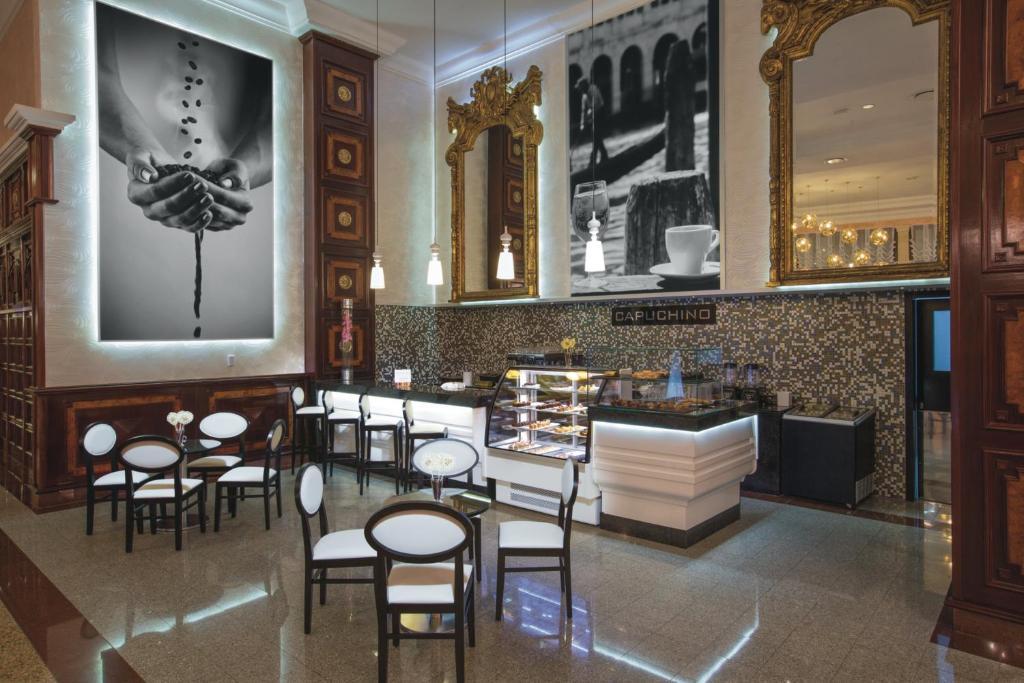 Kafejnīca ar elegantu interjeru, kurā redzami melnbalti mākslas darbi un moderns stils, kas papildina apmeklētāju pieredzi. Ideāla vieta relaksācijai un kafijas baudīšanai.